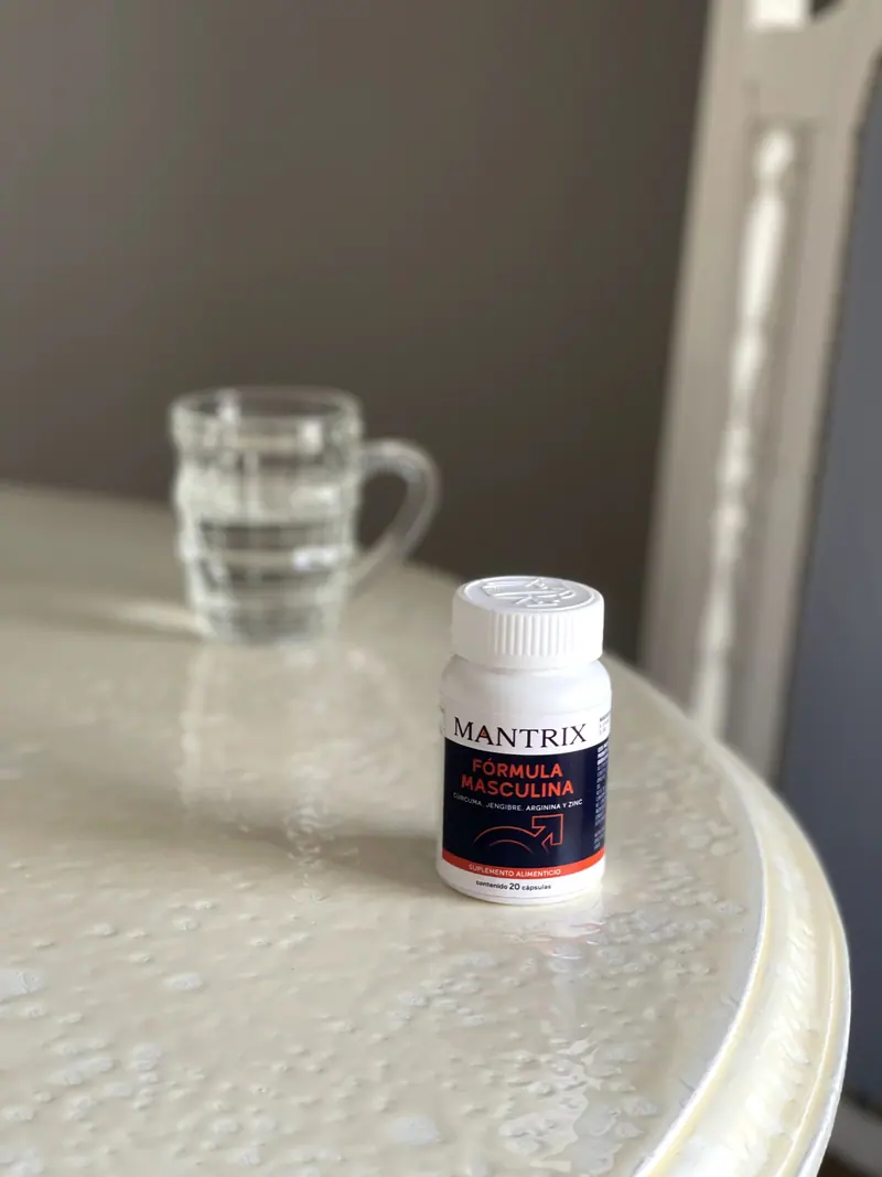Mantrix Fórmula Masculina: frasco junto a un vaso de agua sobre una mesa